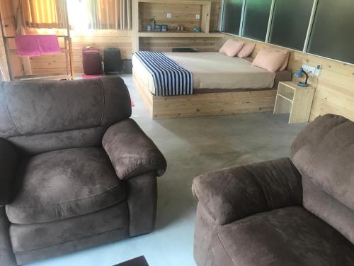 a bedroom with a bed and a couch and chairs at Country Homes in Ella