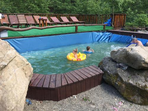 ein paar Leute in einem Schwimmbad in der Unterkunft Vatra Hotel in Jaremtsche