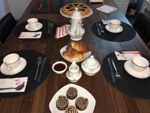 a table with plates of pastries and cups of coffee at B&B Vista su Roma in Marco Simone