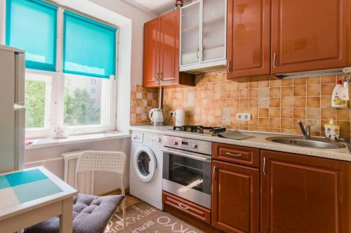 a kitchen with a sink and a washing machine at Pacific Centre Park Gorki in Minsk