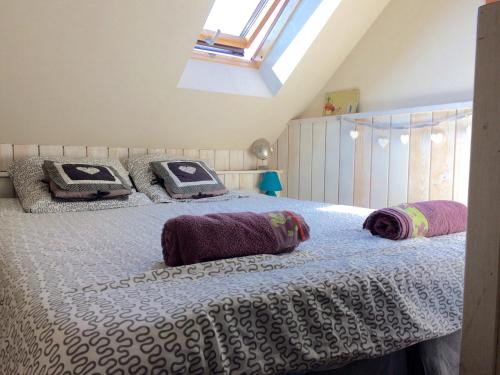 a bedroom with a bed with pillows on it at la baie des voiles ,vue lac d'Annecy ,plage privée in Duingt