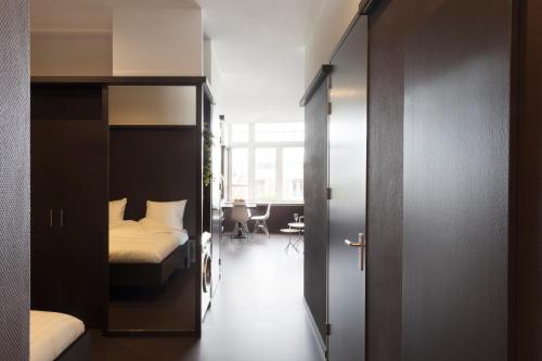 a bedroom with a bed and a room with a table at 2L Hof van Holland apartments in Noordwijk