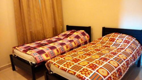 two beds in a room with a quilt at SL Apartment in Cameron Highlands
