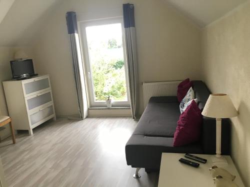 a living room with a bed and a window at Ferienhaus Am Park Leipzig in Leipzig