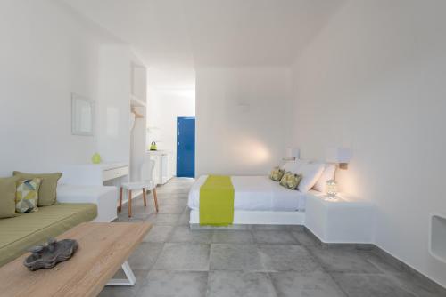 a white bedroom with a bed and a couch at Anemomilos in Oia