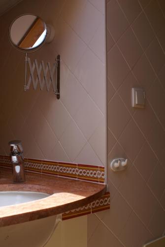 a bathroom with a sink and a mirror at Loft Paços da Vila in Ribeira Brava