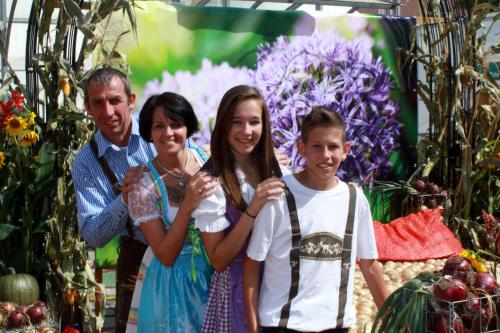 a family posing for a picture in front of flowers at Appartementhaus Thermeneck in Laa an der Thaya