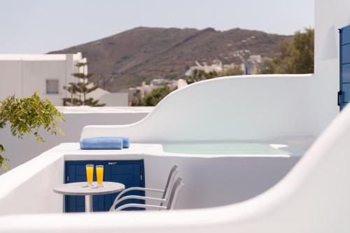 a table and chairs on a balcony with a view at Anemomilos in Oia