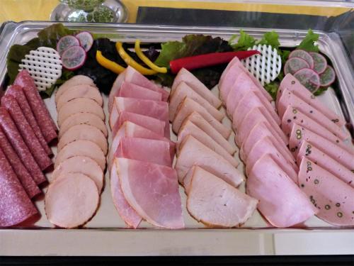 a tray of ham and other meats and vegetables at Hotel Am Kurpark in Malente