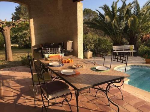 a patio with a table and chairs next to a pool at Lac Saint Esprit in Fréjus