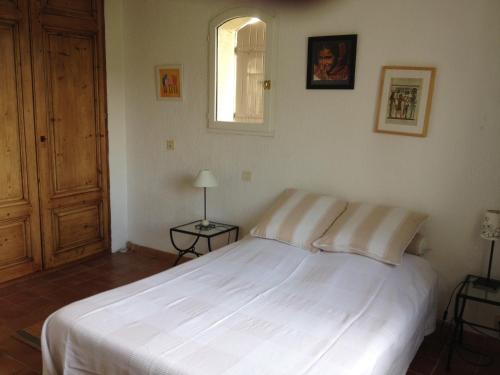 a bedroom with a white bed and a window at Lac Saint Esprit in Fréjus