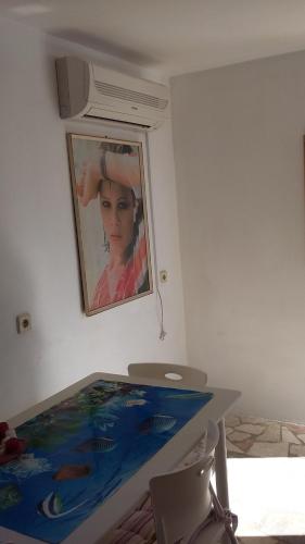 una pintura de una mujer en una pared junto a una mesa en Apartments Miriam Karol, en Rukavac