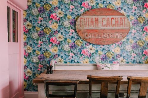 a dining room with a table with flowers on the wall at The Swan Hotel and Spa in Newby Bridge