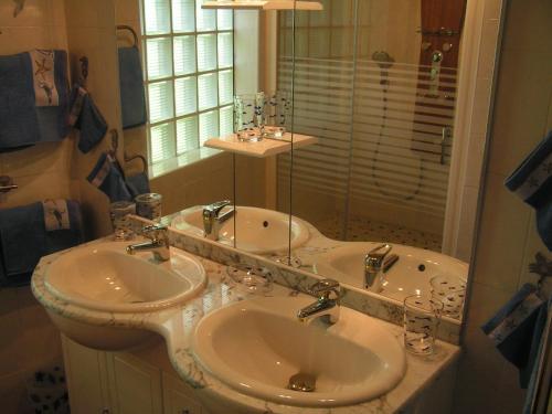 a bathroom with two sinks and a shower at Chambres d'Hôtes La Forterie in Vairé