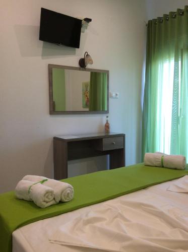 a bedroom with a bed and a mirror and a television at Studios Nopi-Zoi in Skiathos Town