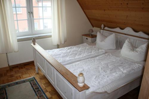 a bedroom with a white bed with white sheets and pillows at Zur alten Schmiede I (Rechts) in Boltenhagen