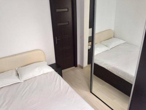 コンスタンツァにあるApartament Larisaの鏡付きの小さな部屋のベッド2台