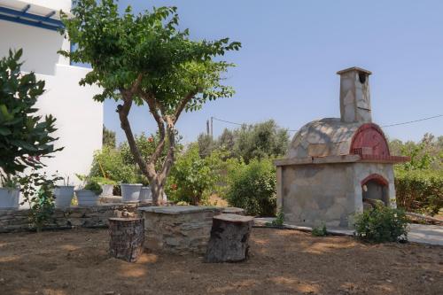 a small stone oven in a yard with trees at Maroussa Studios in Agia Anna Naxos