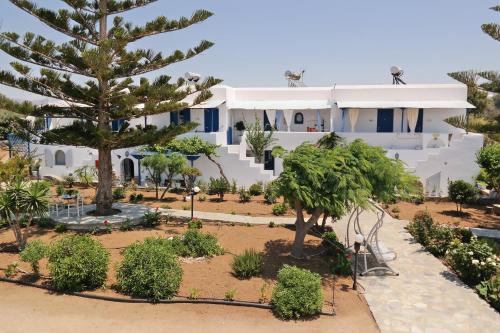 a large white house with trees in front of it at Maroussa Studios in Agia Anna Naxos
