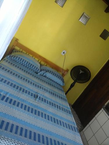 a bedroom with a blue bed with a fan at Ouro Grosso Chales in Iporanga