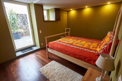 a bedroom with a bed and a large window at Casa do Vizinho in Porto Judeu