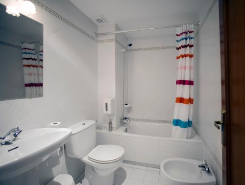 y baño blanco con aseo, bañera y lavamanos. en Casa Rural Maialde, en Elgeta