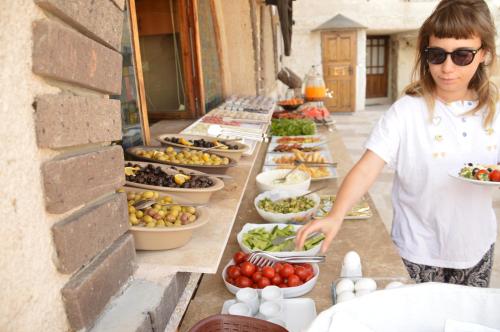 a woman standing in front of a buffet of food at Elite Cave Suites in Goreme