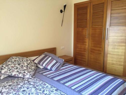 a bedroom with a bed with two pillows and a closet at Bouznika Charly's in Bouznika