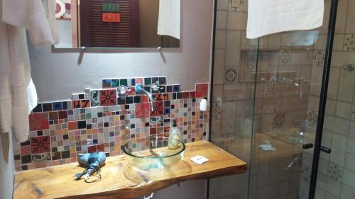 a bathroom with a sink and a glass shower at Be Hospedagem in Lumiar
