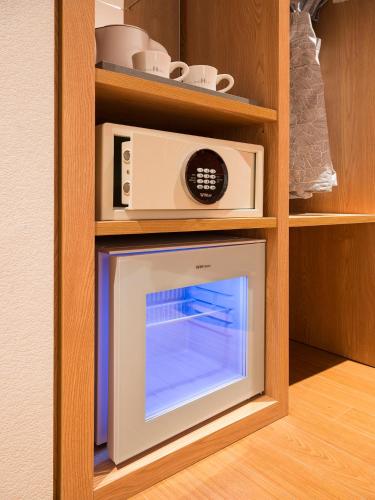 a microwave oven sitting inside of a cabinet at Hotel Park Habio in Seoul