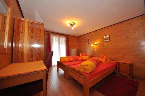 Zimmer mit einem Bett mit orangefarbenen Kissen in der Unterkunft Apartment Regina in Grächen
