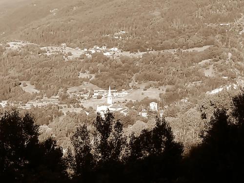 a black and white photo of a town with a church at La Pietra Felice in Introd