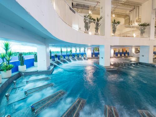 a large swimming pool with chairs in a building at Hotel Park Habio in Seoul