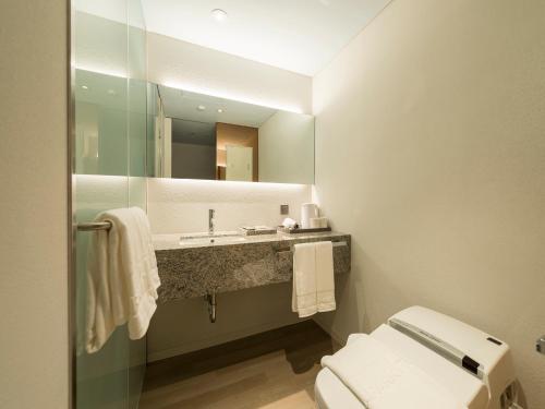 a bathroom with a sink and a toilet and a mirror at Hotel Park Habio in Seoul