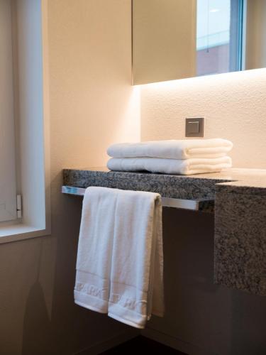 a bathroom with towels on a counter and a mirror at Hotel Park Habio in Seoul