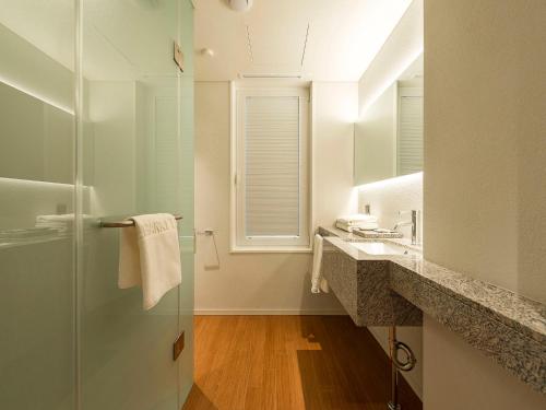 a bathroom with a shower and a sink and a mirror at Hotel Park Habio in Seoul