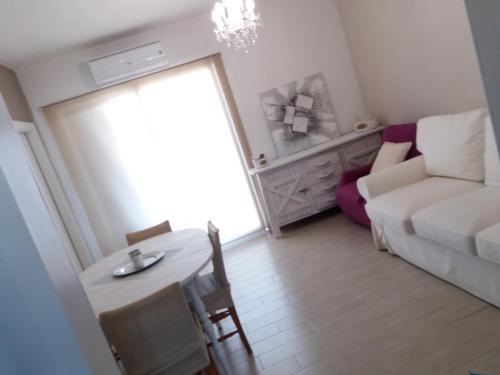 een woonkamer met een witte bank en een tafel bij Apartamentos Lorena 1A in Segur de Calafell