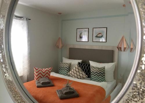 a bedroom with a bed with pillows and a mirror at Wohlfühl-Apartments in Zingst in Zingst