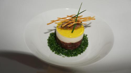 a dessert on a white plate with a yellow topping at Caschu Alp Boutique Design Hotel Stoos - adults only in Stoos
