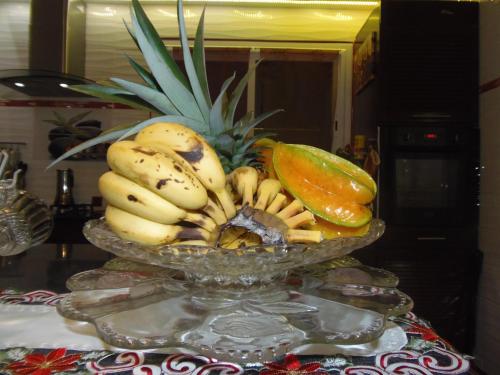 a bowl of bananas and other fruits on a table at Villa Mancina in Capesterre-Belle-Eau