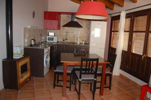 cocina con mesa y sillas y cocina con TV en casa sampietro 2, en Alquézar