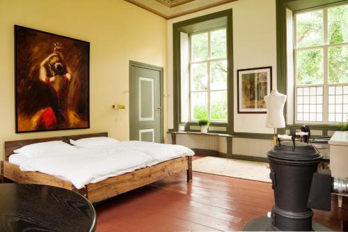 Pastorie Tijdverblijf في Zuidhorn: غرفة نوم بسرير ودهان على الحائط