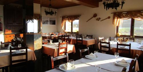 een restaurant met tafels en stoelen met witte tafelkleden bij Pedras Lavradas in Teixeira de Baixo