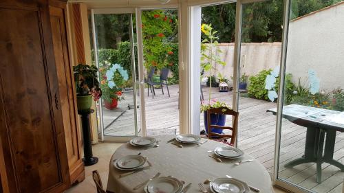 a room with a table and a patio with sliding glass doors at Castel Parc in Périgny