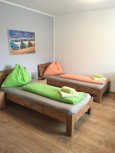 two beds in a room with green and orange sheets at Roccos Raum in Kapfenberg