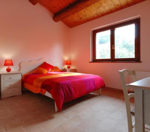 a bedroom with a bed and a window at Mazzamurello in Caldarola
