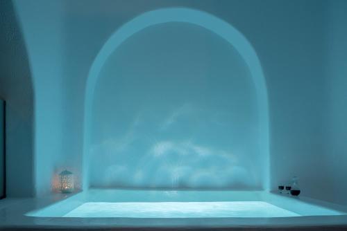 a bath tub with a blue light in a bathroom at Anemomilos in Oia