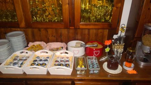 a table topped with boxes of donuts and plates at Garnì Defrancesco in Campitello di Fassa