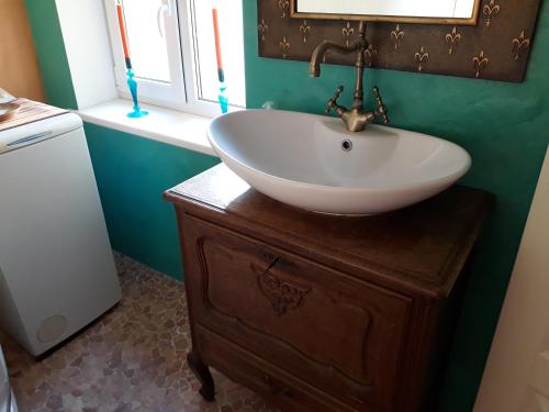 een badkamer met een witte wastafel op een houten dressoir bij Theodori Holiday House in Pärnu
