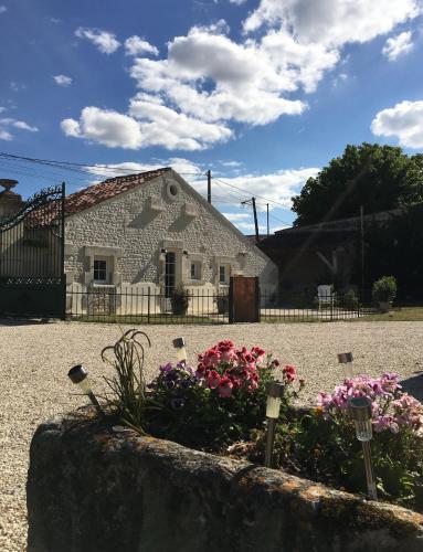 a stone building with flowers in front of it at Logis de L'Arceau in Celles